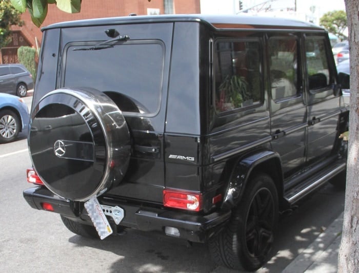 A broken license plate hangs from the bumper of Kendall Jenner's Mercedes-Benz sport utility vehicle (SUV)