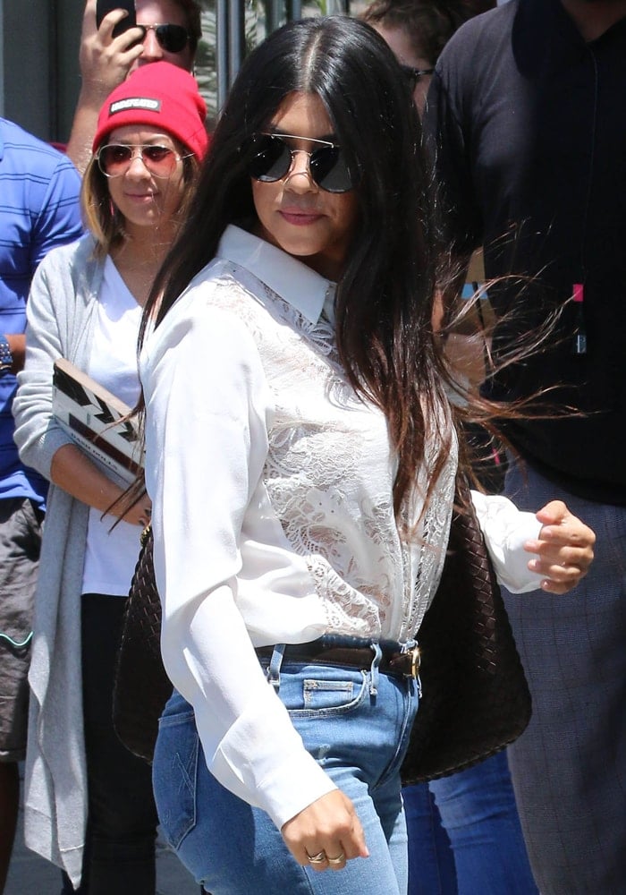 Kourtney Kardashian's lace shirt tucked into a pair of flared pants