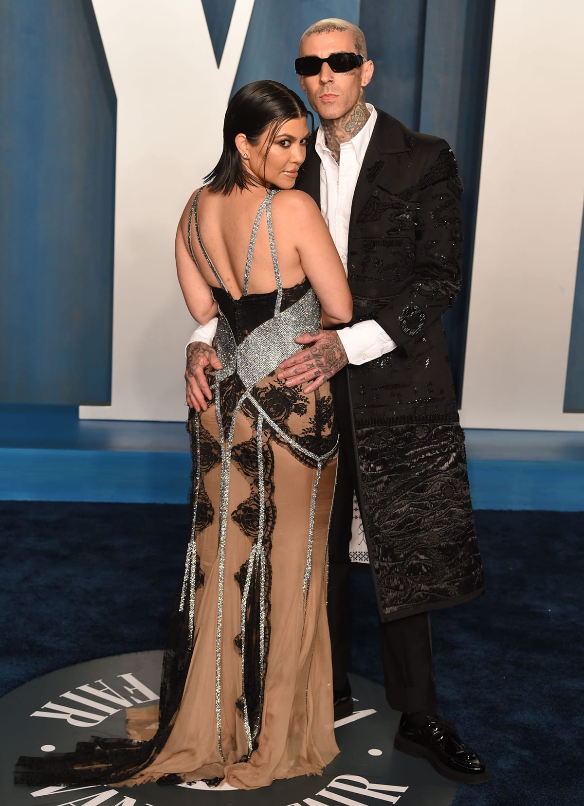 Kourtney Kardashian in a vintage Dolce & Gabbana dress and Travis Barker in a Thom Browne ensemble at the 2022 Vanity Fair Oscar Party