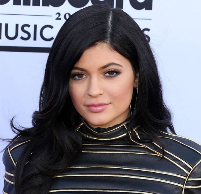 Kylie Jenner attends the 2015 Billboard Music Awards in a striking gold and black striped leather dress