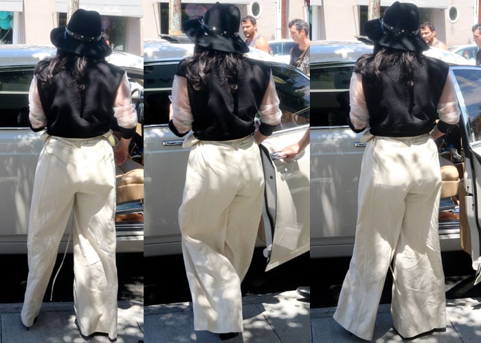 Lady Gaga rocks a wide-brimmed hat, round sunglasses, and pointed toe patent pumps