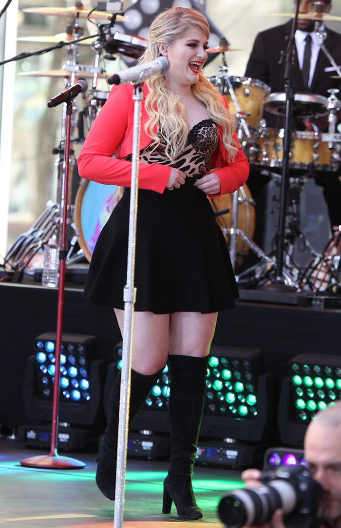 Meghan Trainor in a daring cleavage-baring leopard-print top, a coral bolero, and a black miniskirt