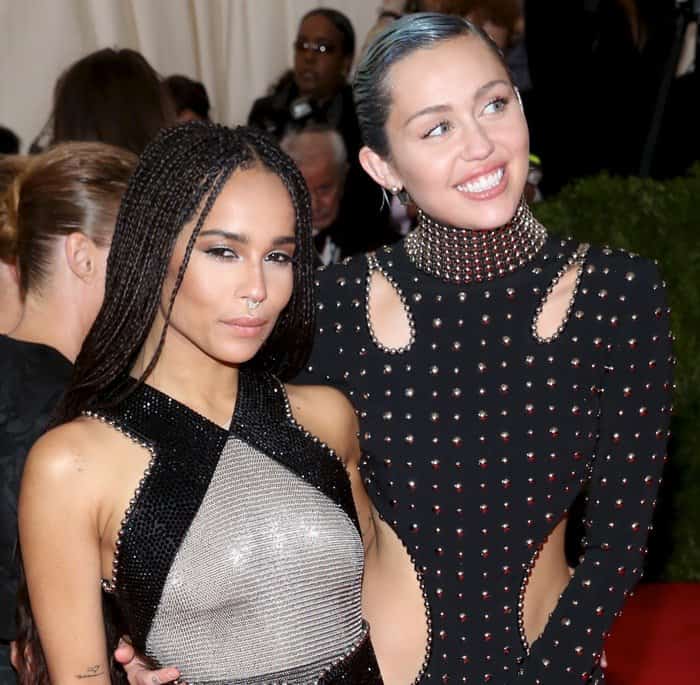 Miley Cyrus, standing taller in studded Alexander Wang, poses with Zoë Kravitz, who sports a braided hairstyle and a sheer, metallic gown at the 2015 Met Gala