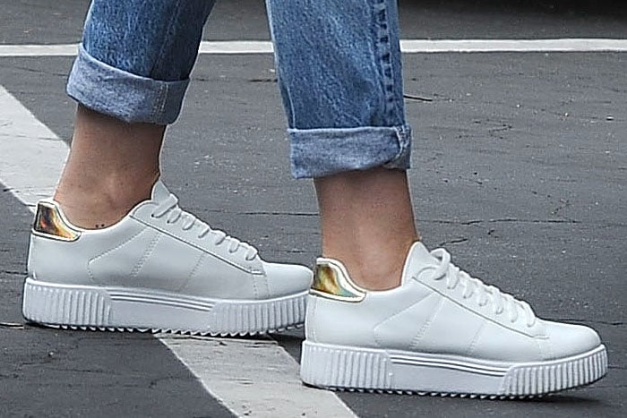 Miley Cyrus' white River Island platform sneakers with holographic gold trims on the padded heels