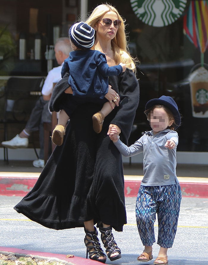 Rachel Zoe accessorized with layers of gold necklaces, gold earrings, and a selection of rings and bracelets