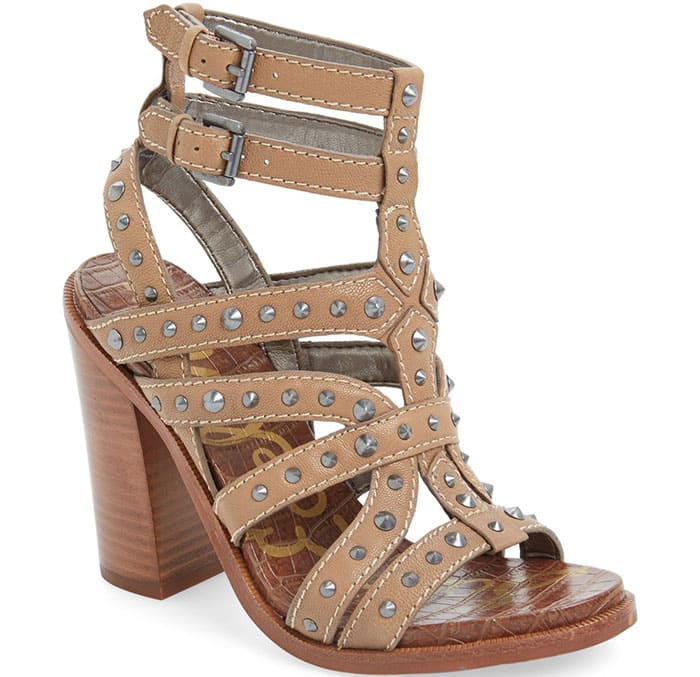Polished cone studs play up the edgy attitude of a dramatic stacked-heel sandal topped with twin ankle straps