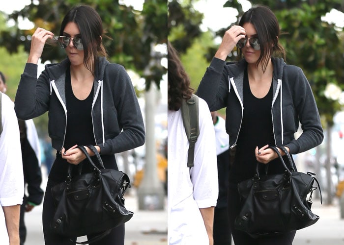 Kendall Jenner wearing a black zip up hooded jacket