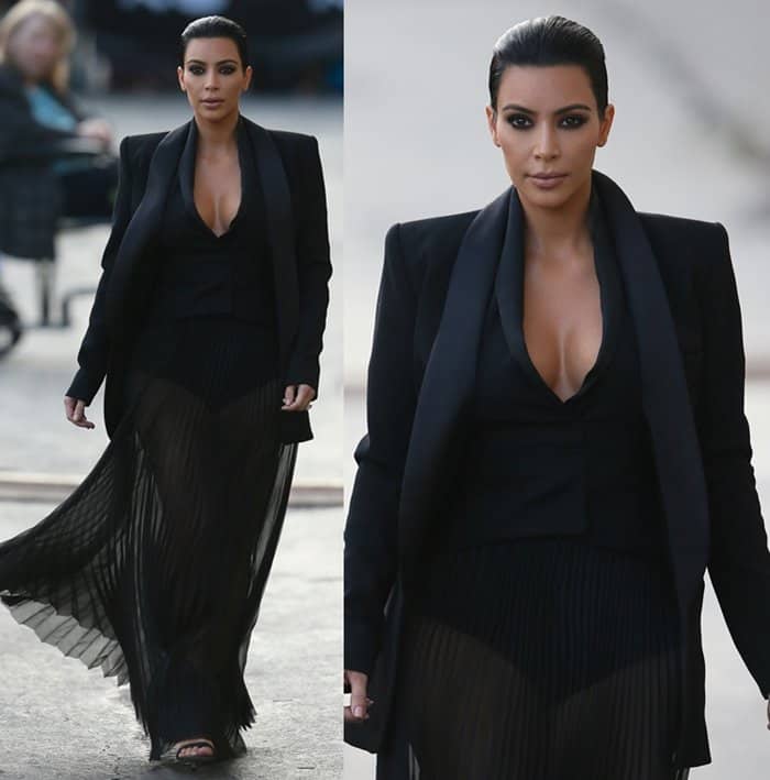 Kim Kardashian exudes elegance in a black ensemble featuring a plunging neckline and sheer pleated skirt, paired with a structured blazer for a guest appearance on Jimmy Kimmel Live!