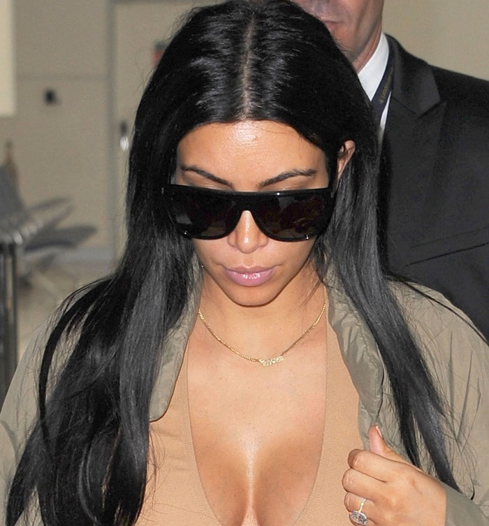 Kim wore her long dark locks down and let the spotlight fall on her cleavage as she made her way through the airport