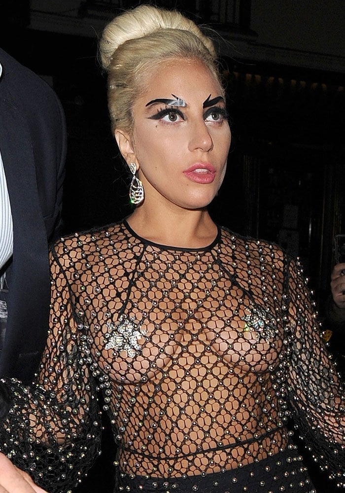 Lady Gaga turns heads in London wearing a daring sheer mesh dress adorned with crystal embellishments, bold eye makeup, and elegant statement earrings