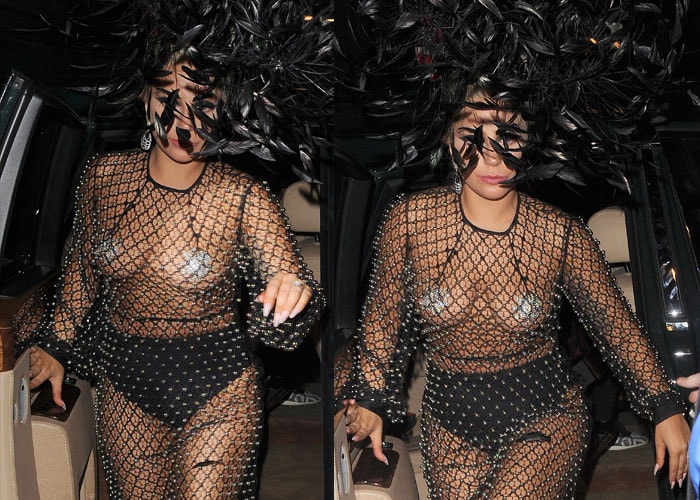 Lady Gaga makes a dramatic entrance wearing an extravagant black feathered headpiece that adds theatrical flair and height