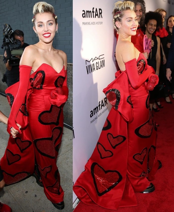 Miley Cyrus poses on the red carpet of the 2015 amfAR gala in a custom heart-printed Moschino gown by Jeremy Scott