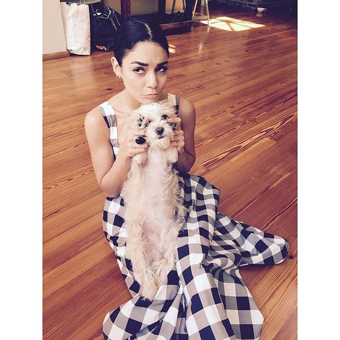 Vanessa poses for a photo with her pup while wearing her Dolce & Gabbana gingham dress