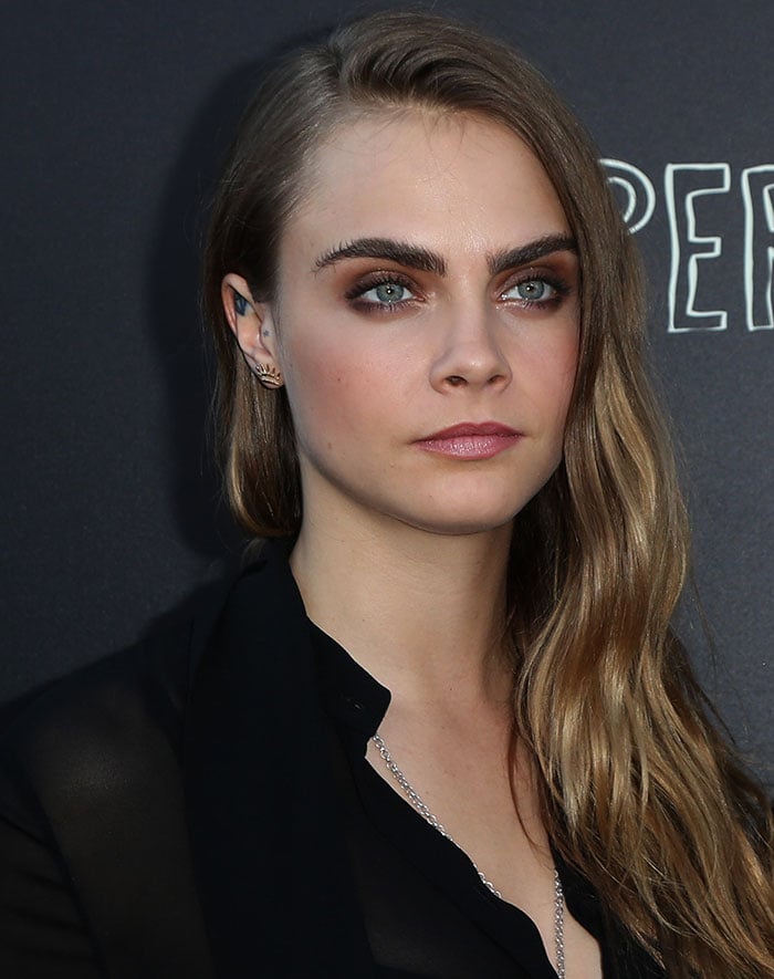 Cara Delevingne wore her long hair down in loose waves with a deep side part