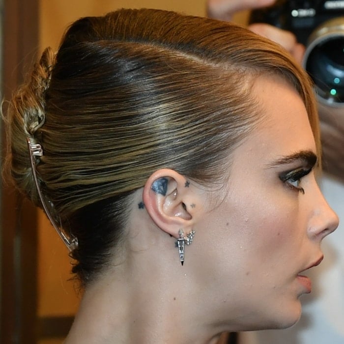Cara Delevingne's right ear tattoos of a diamond and stars