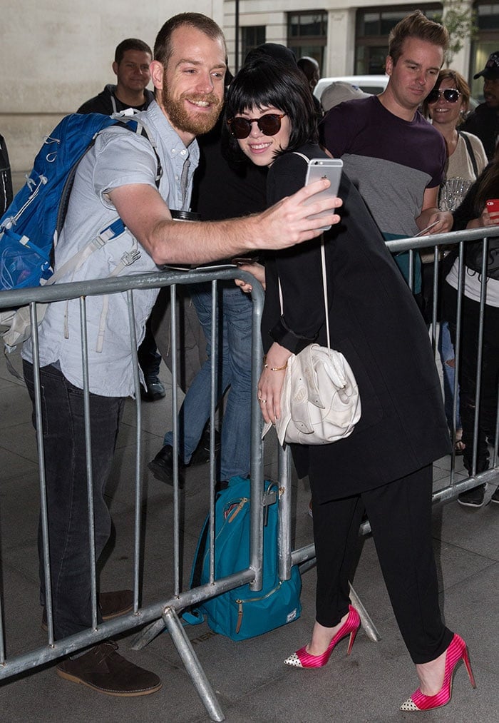 Carly Rae Jepsen takes a photo with a fan outside the BBC Radio 1 studios in London