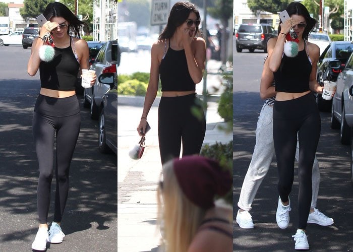 Kendall Jenner hides her eyes from the cameras as she takes a stroll in her athletic wear, coffee in hand