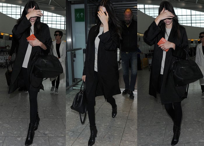 On July 14, 2015, Kendall Jenner arrived at Heathrow Airport wearing Prada top-buckle lace-up booties, a Marc Jacobs smooth medium incognito bag in black nickel, and a Goyard passport holder