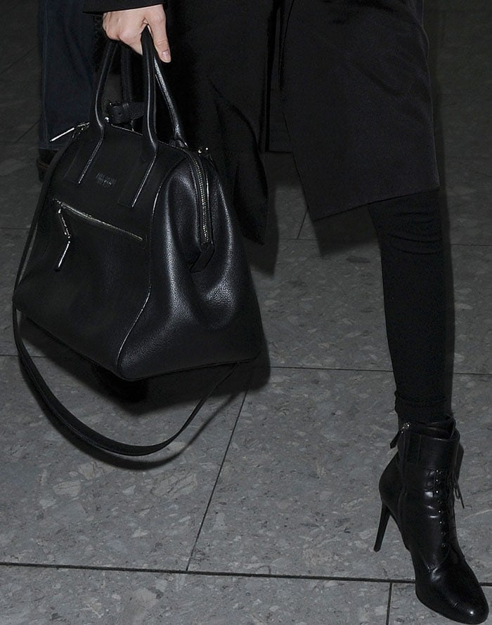 Kendall Jenner's black-on-black airport outfit features a lot of leather, including stiletto ankle booties and a black handbag
