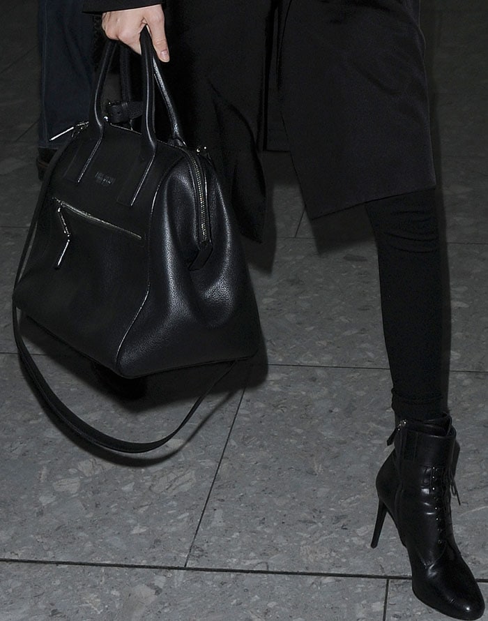 Kendall Jenner's black-on-black airport outfit features a lot of leather, including stiletto ankle booties and a black handbag