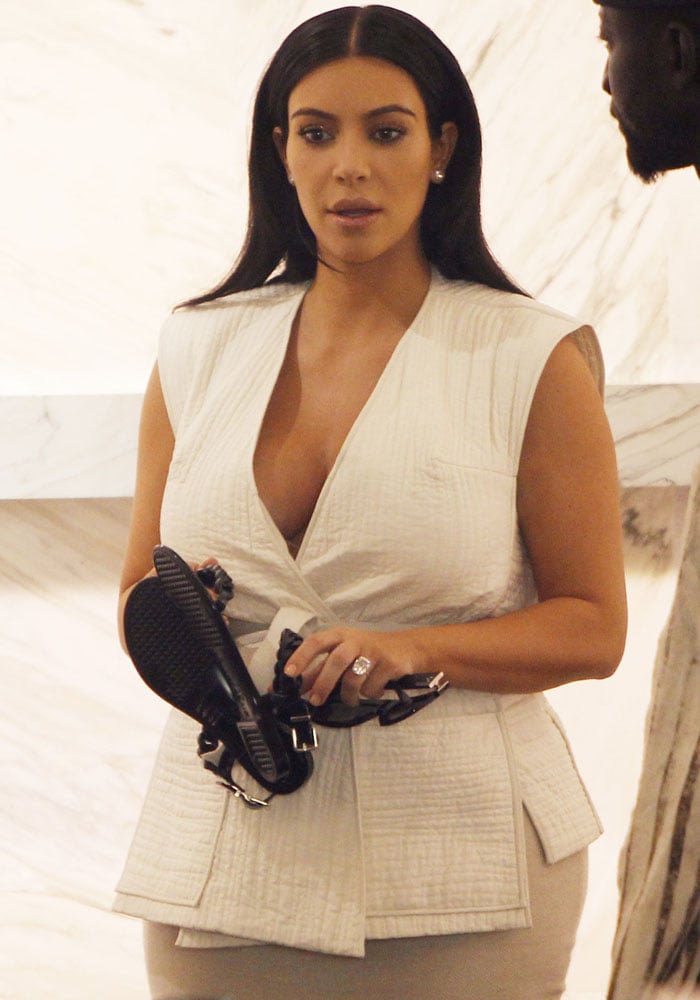 Kim Kardashian browses sandals while shopping in Paris, dressed in a chic quilted white top and showing off her dazzling diamond ring