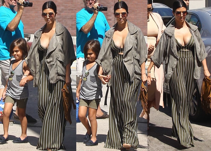 Kourtney Kardashian in dark green pinstriped palazzo pants