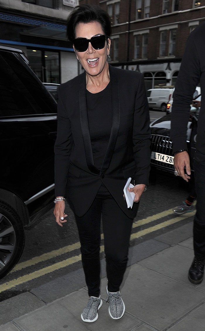 Kris Jenner rocks an all-black look comprised of slim-fit pants, a tuxedo blazer and a pair of Yeezy Boost 350 sneakers