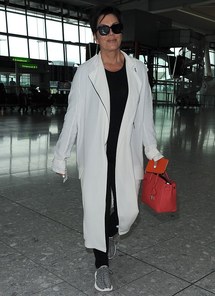 Kris Jenner rocks a neutral-and-red look as she arrives at Heathrow Airport in London, England, on July 14, 2015