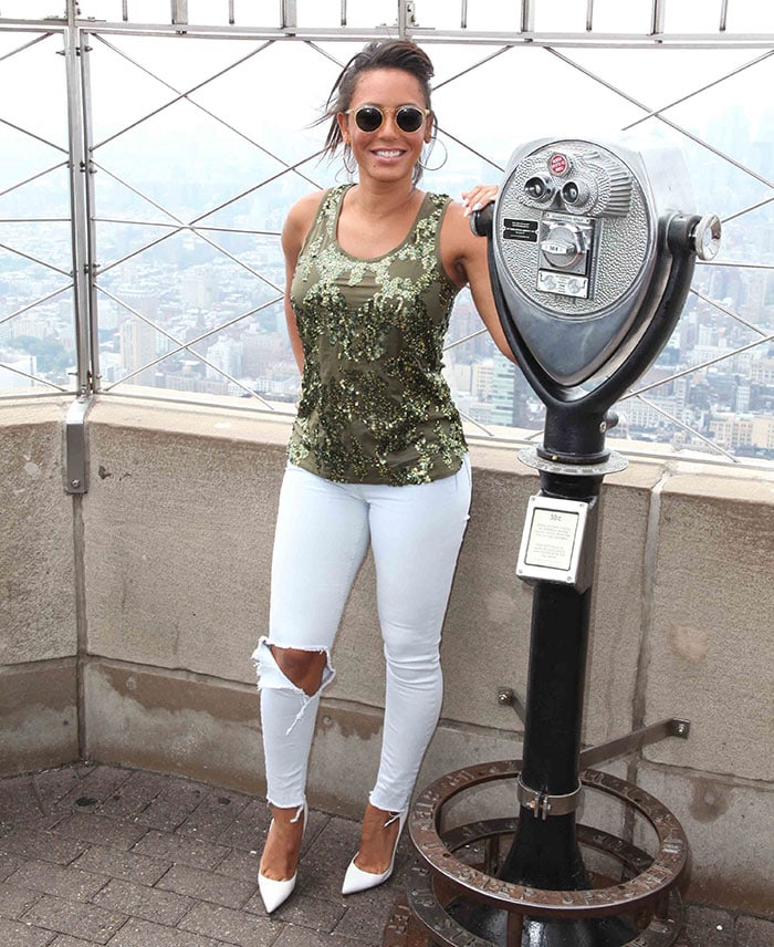 Mel B accessorized with hoop earrings, a ring, a watch, and some bracelets