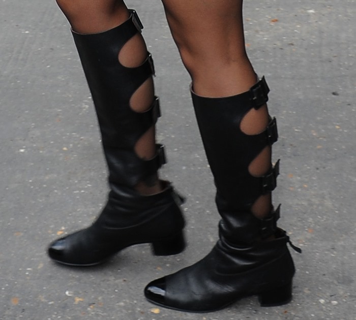 Rita Ora shows off the detailing on her black leather knee-high Chanel boots