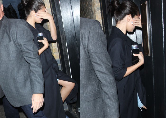 Selena Gomez hides her face with a white-manicured hand as she arrives for a birthday dinner in London