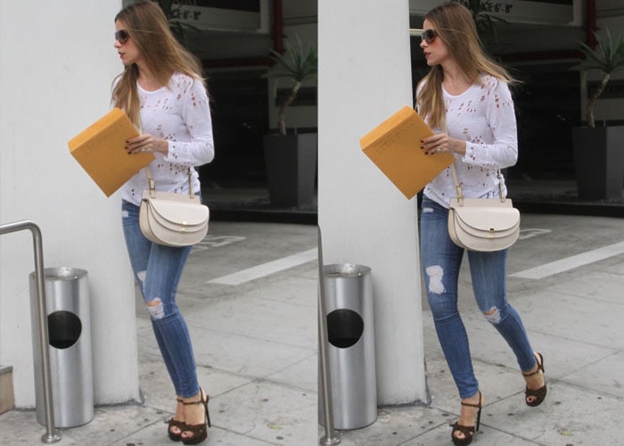 Sofia Vergara holds an envelope as she struts through town in platform heels