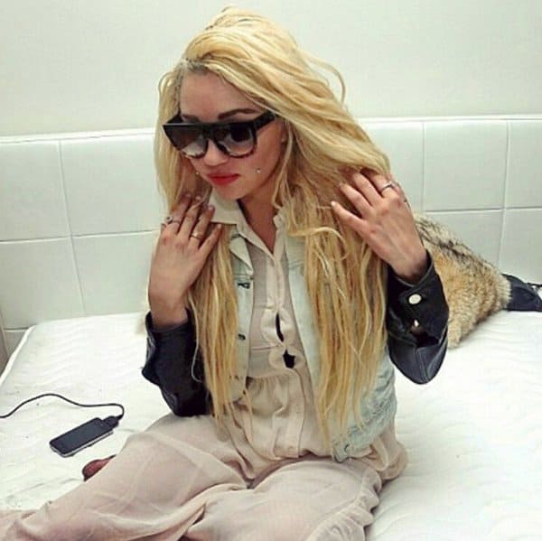 Amanda Bynes, during her turbulent years in 2013, sported platinum blonde hair, oversized sunglasses, and a layered outfit featuring a denim vest over a sheer blouse