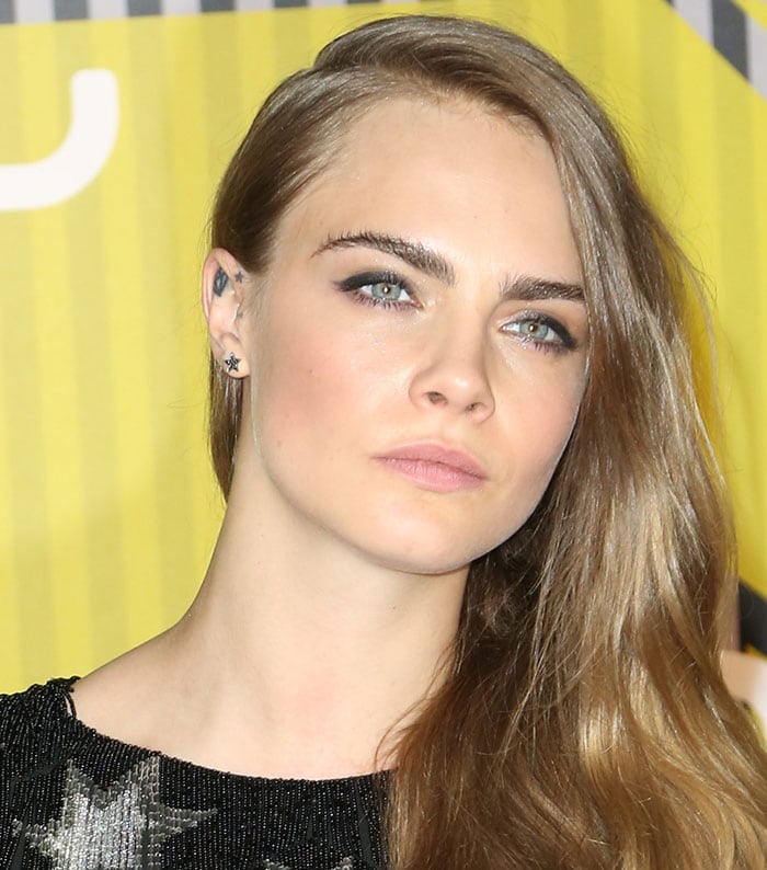 Cara Delevingne wore her hair down in loose waves with a deep side parting