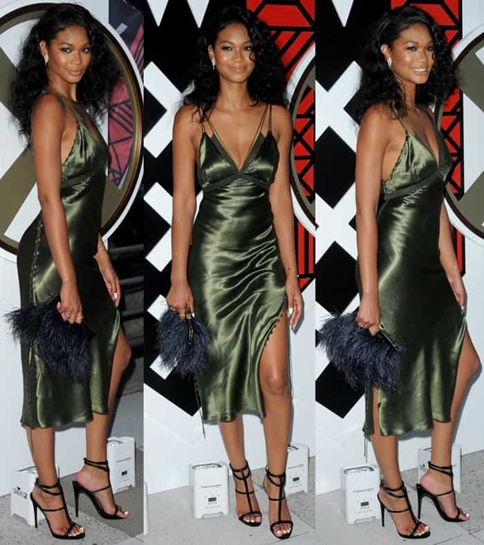 Chanel Iman styled her olive-green Alexander Wang satin slip dress with strappy black Giuseppe Zanotti heels, a luxurious furry Kate Spade clutch, and simple, elegant jewelry, letting her natural beauty and the dress's sleek design take center stage