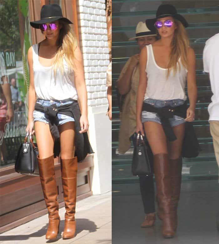 Chrissy Teigen goes shopping in style with tiny shorts, over-the-knee boots, and a fedora