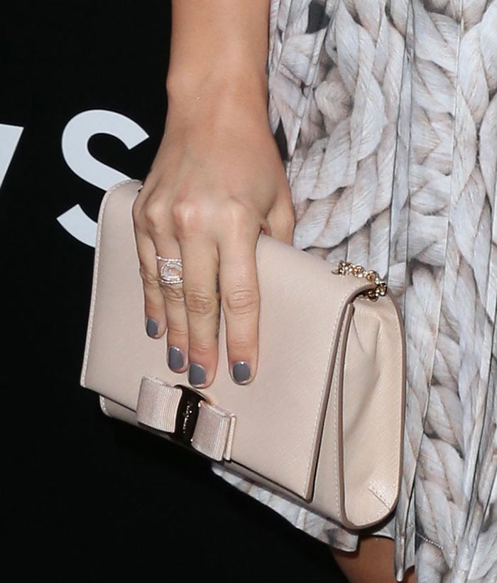 Demi Lovato toting a bisque Salvatore Ferragamo “Vara” bow clutch