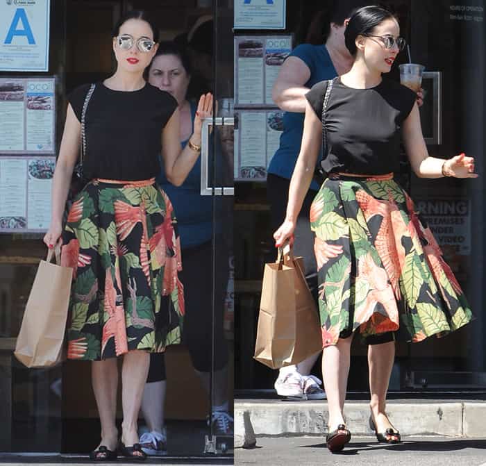 Dita Von Teese steps out in a chic printed midi skirt paired with a black shirt, peep-toe flats, and stylish accessories, effortlessly blending comfort with elegance