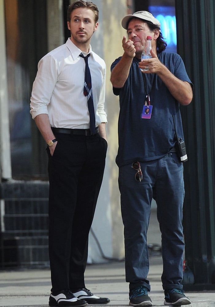 Ryan Gosling receives last minute instructions before filming his scenes as his co-star Emma Stone has fun with the film crew