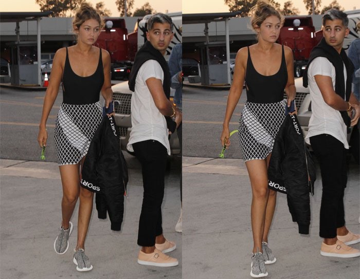 Gigi Hadid arrives at Taylor Swift's concert in a monotone look comprised of a sideboob-baring top