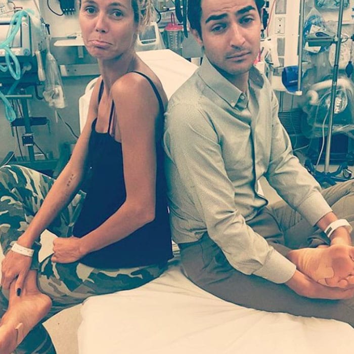 Model Heidi Klum and Project Runway judge Zac Posen both show off the bandages they received after stepping on rusty nails on the set of their show