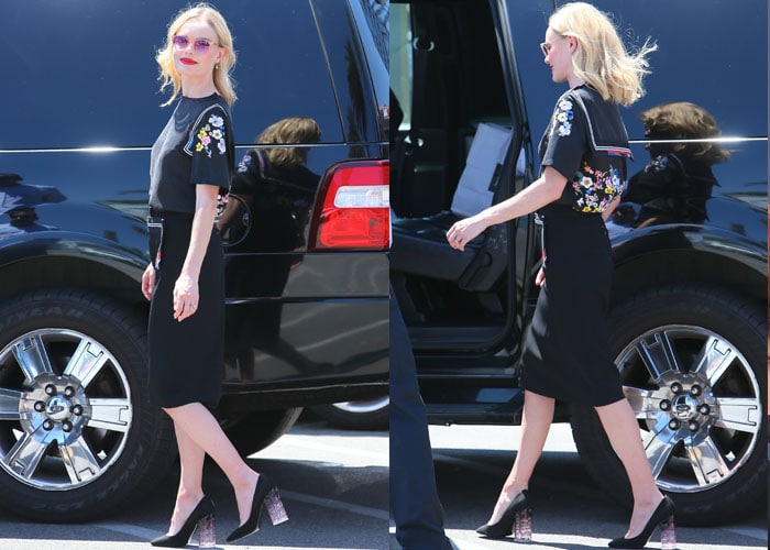Kate Bosworth's blonde hair blows in the wind as she struts alongside a black vehicle