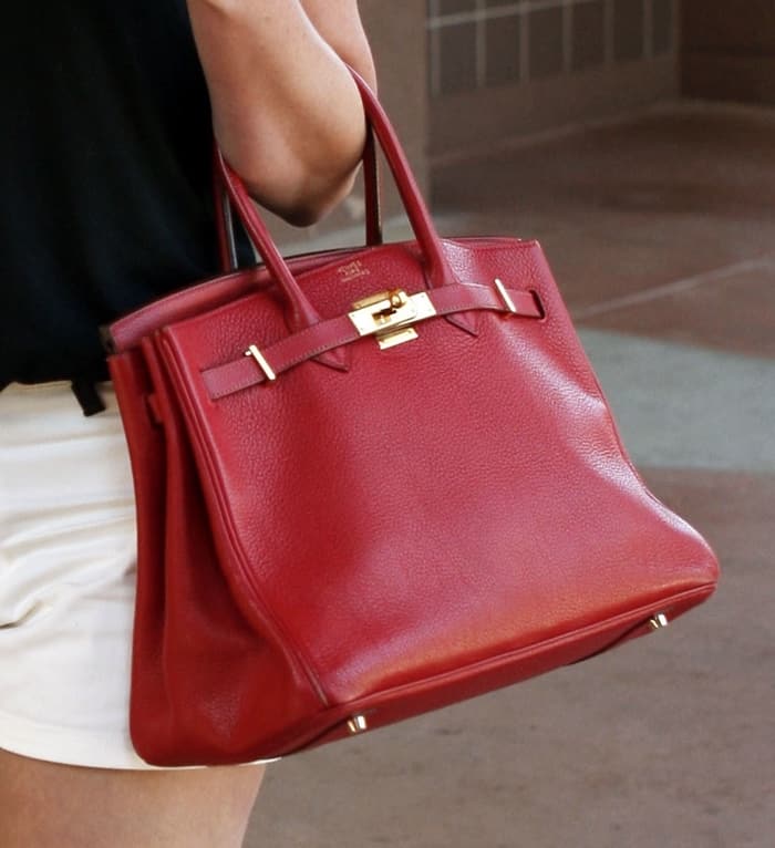 Katherine Heigl's fiery red Hermès Birkin bag, crafted from grained leather with gold-tone hardware, adds a bold and timeless statement to her casual ensemble