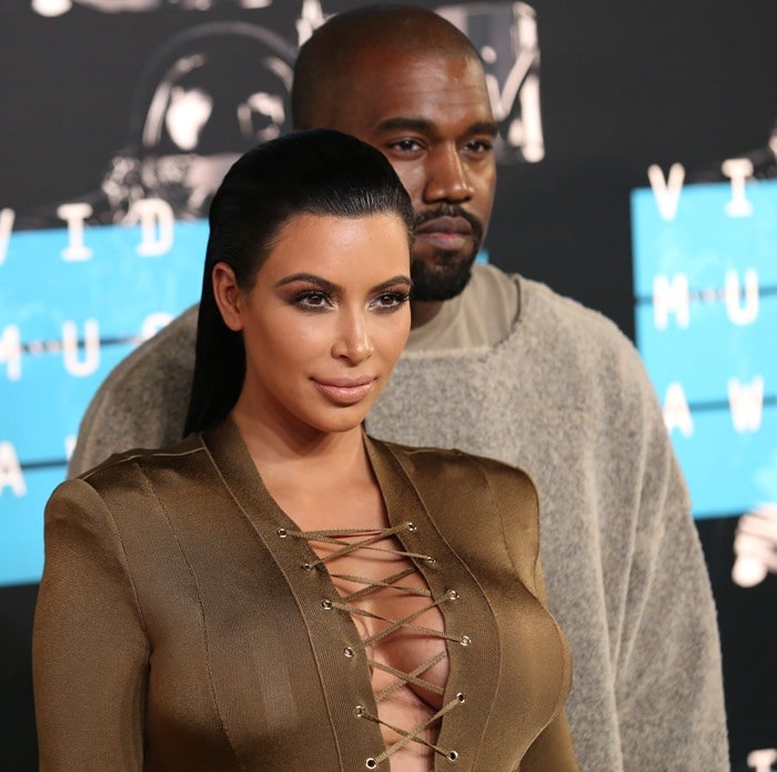 Kim Kardashian showed off all her curves in a dark gold military-inspired Balmain gown featuring gigantic pockets and head-to-toe lace-up detail