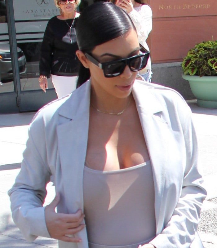 Kim Kardashian sports a slicked-back dark ponytail and large black sunglasses for her salon visit
