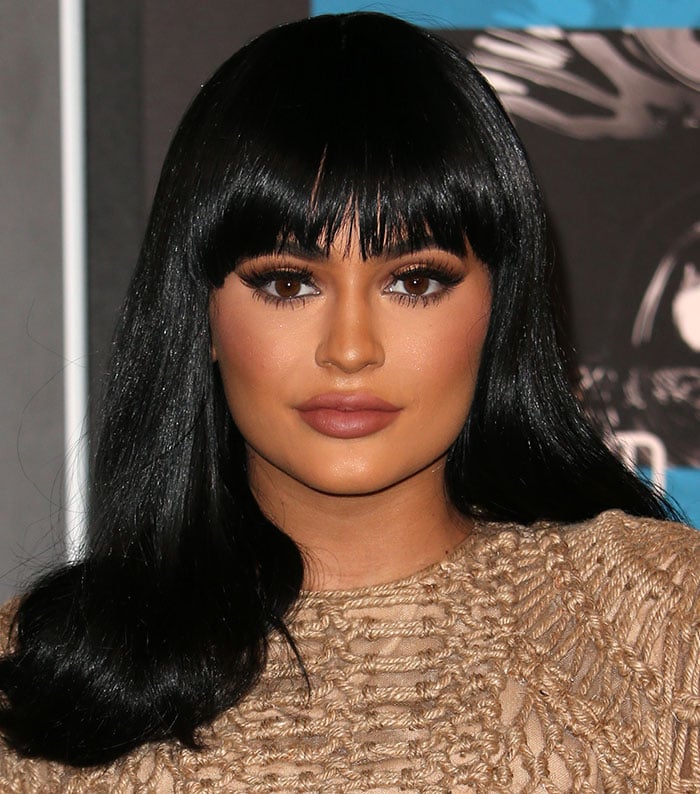 Kylie Jenner shows off her full pout, bronze makeup, and Bettie Page–inspired wig