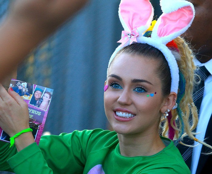 Miley Cyrus shows off her bunny ears, electric blue eyeliner, face stickers and earrings as she leaves ABC Studios in Los Angeles