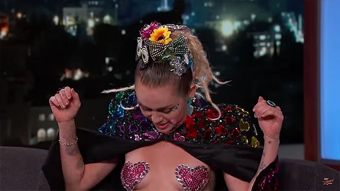 Miley Cyrus flashing the heart nipple tapes she wore during her Jimmy Kimmel Live! guest appearance aired on August 26, 2015