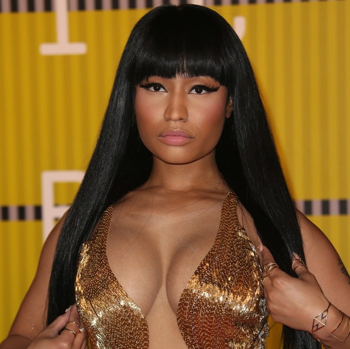 Nicki Minaj wears her trademark dark hair and bangs down and straight 