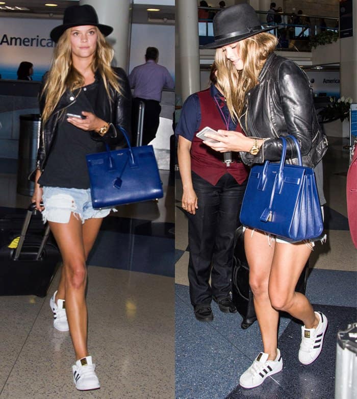 Nina Agdal keeps it casual and cool in faded denim, untucked black shirt, moto jacket, and sneakers